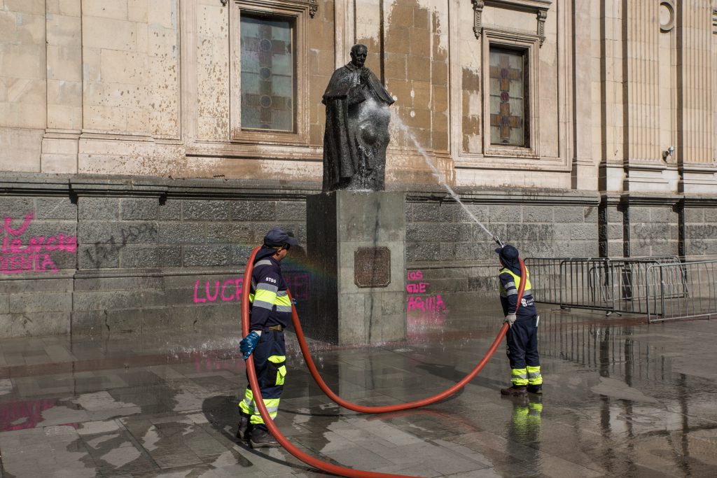 Feuerwehrmänner säubern Statue